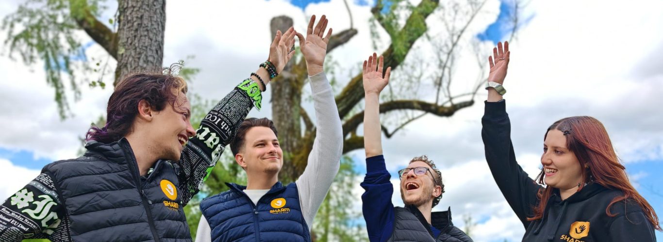 Photo de l'équipe Shariti qui lève les bras vers le ciel ensemble